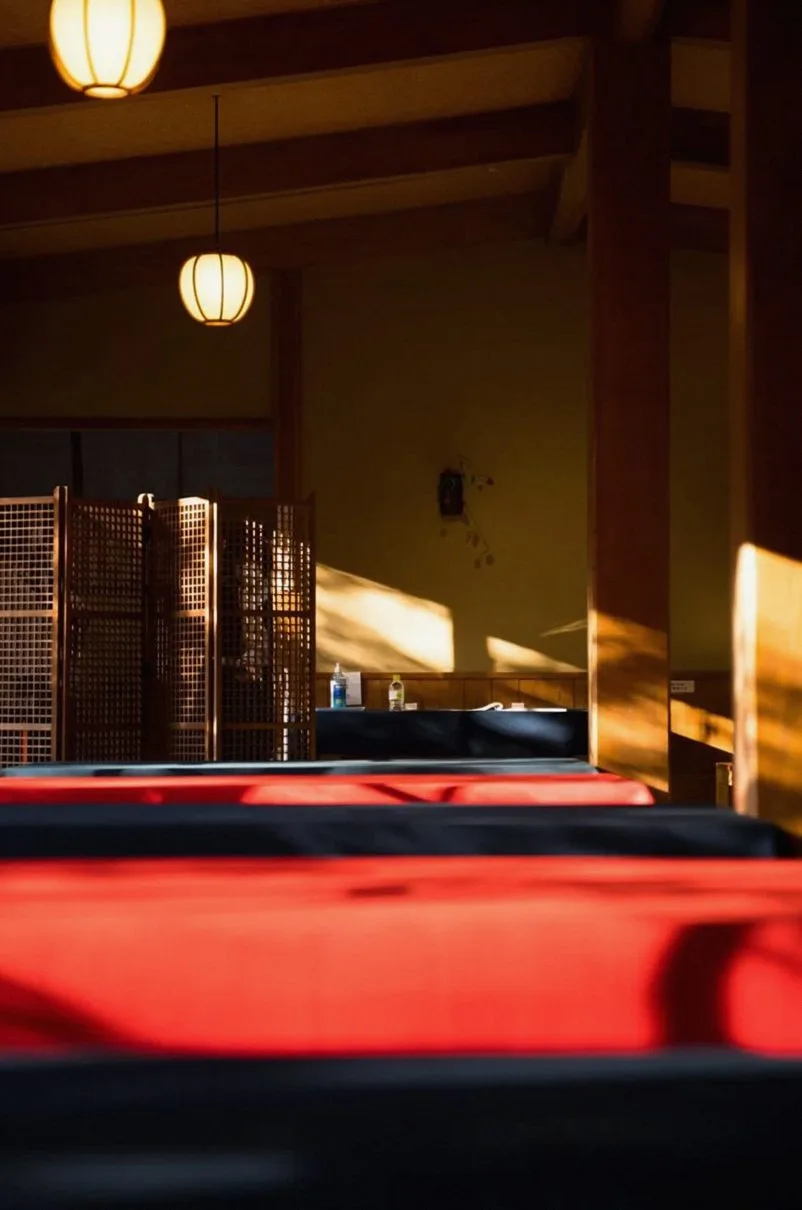 Sunlit interior with red floor cushions and warm lamps